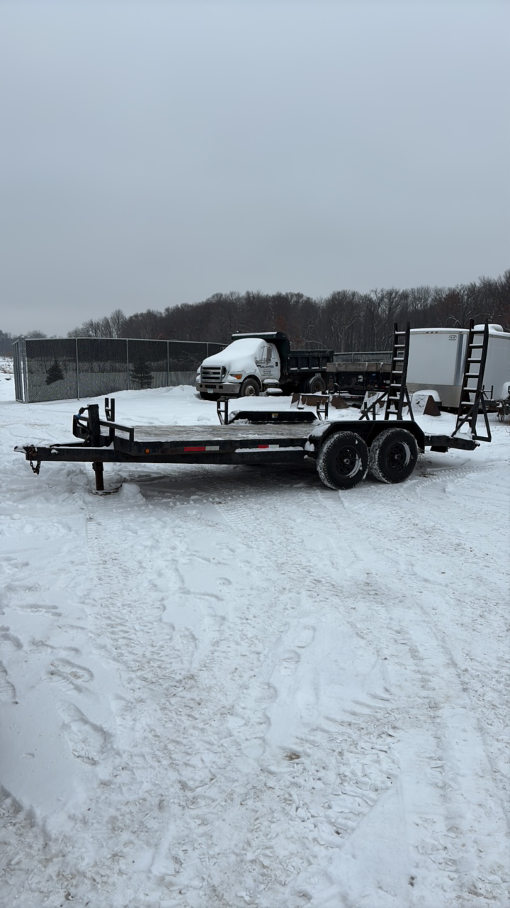2002 PJ Flatbed equipment trailer with two loa with two loading ramps.