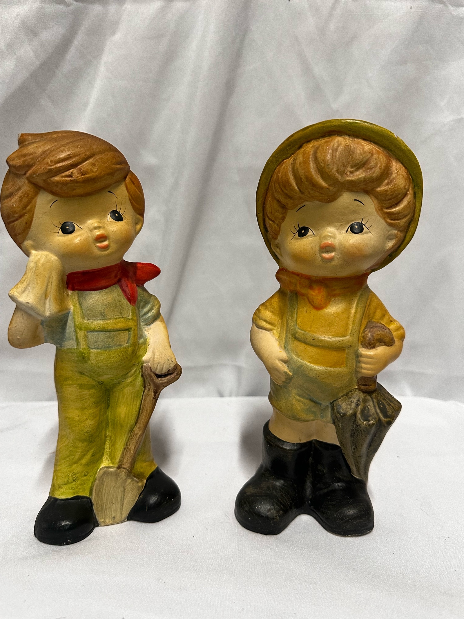 Pair of vintage ceramic piggy bank figurines, often referred to as Hummel-like or Homco style
