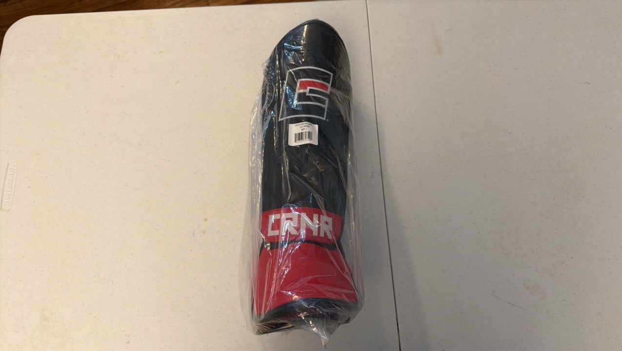 lot 103 image: NEW CRNR L Kids Shin Guards