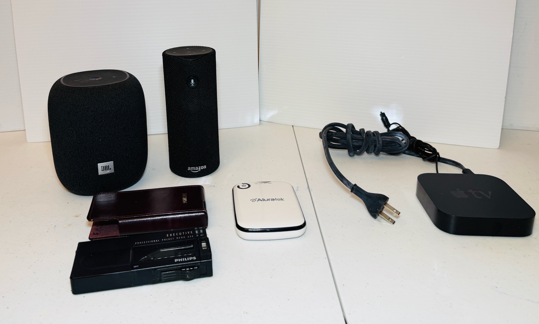 lot 108 image: (2) WIRELESS Speakers, (1) Apple TV unit, (1) Aluratek portable battery charger & Phillips Pro pocket memo