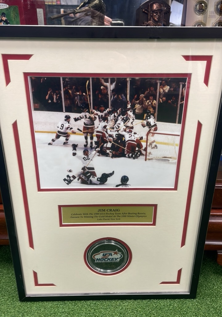 lot 1A image: Miracle On Ice Jim Craig Commemorative 1980 USA Hockey Team after beating Russia, Autograph Jim Craig Puck and Picture nicely presented in Custom Made Frame