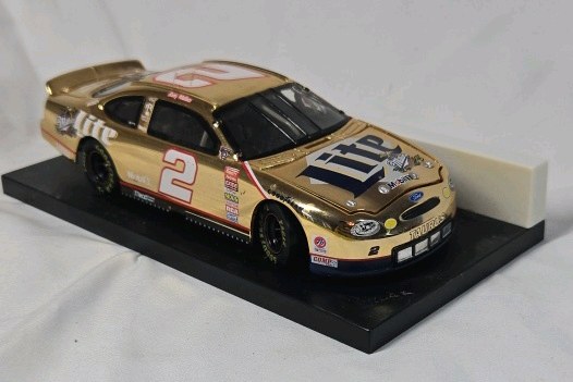 lot 123 image: Rusty Wallace Miller Lite Ford Taurus  Gold Chrome Diecast on Black Base