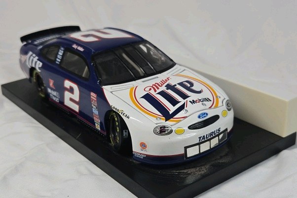 lot 130 image: Rusty Wallace Miller Lite Ford Taurus  Blue and White Diecast on Black Base