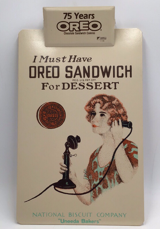 lot 181 image: Vintage Oreo Clipboard  75 Years Oreo Advertising with Woman on Phone Scene