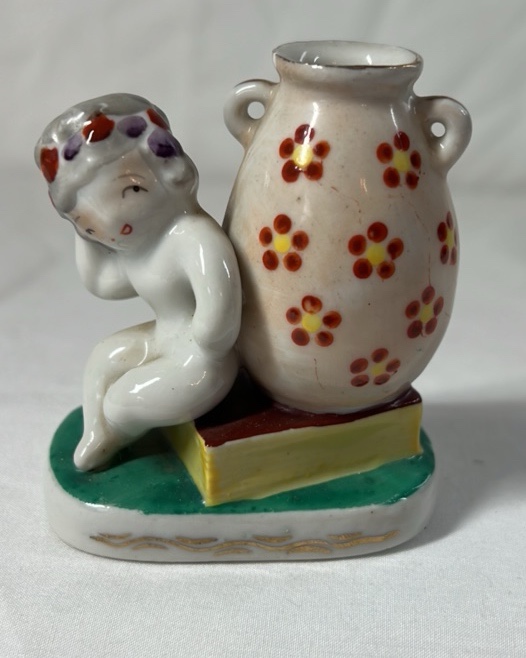 lot 216 image: Occupied Japan Porcelain Figurine  Cherub Leaning on Vase with Flowers