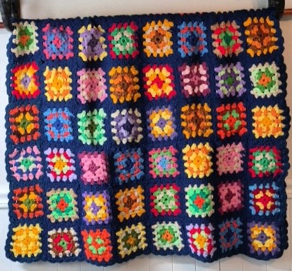 lot 233 image: Vintage Crocheted Granny Square Afghan  Multicolor Floral Motifs on Navy Ground