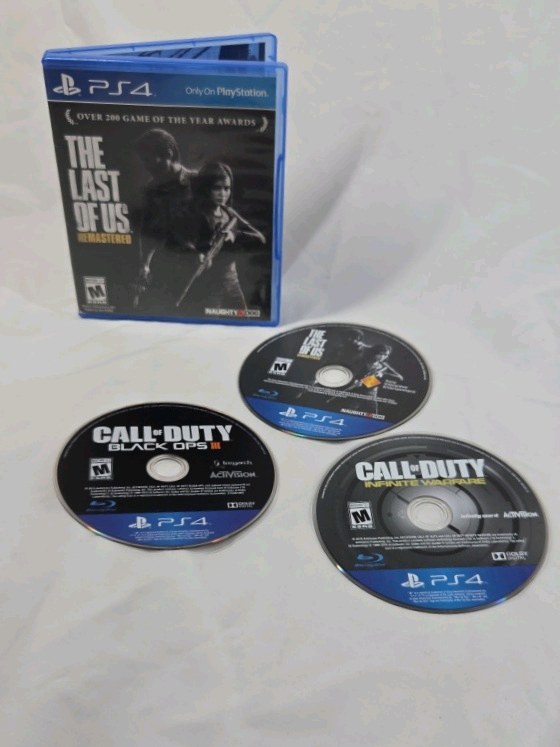 lot 91 image: PlayStation 4 Game Disc Lot  The Last of Us Remastered, Call of Duty Black Ops III, Call of Duty Infinite Warfare