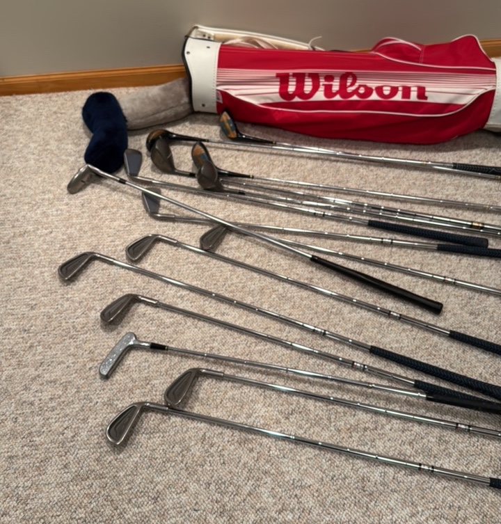 set of Spalding golf clubs and a Wilson golf bag
