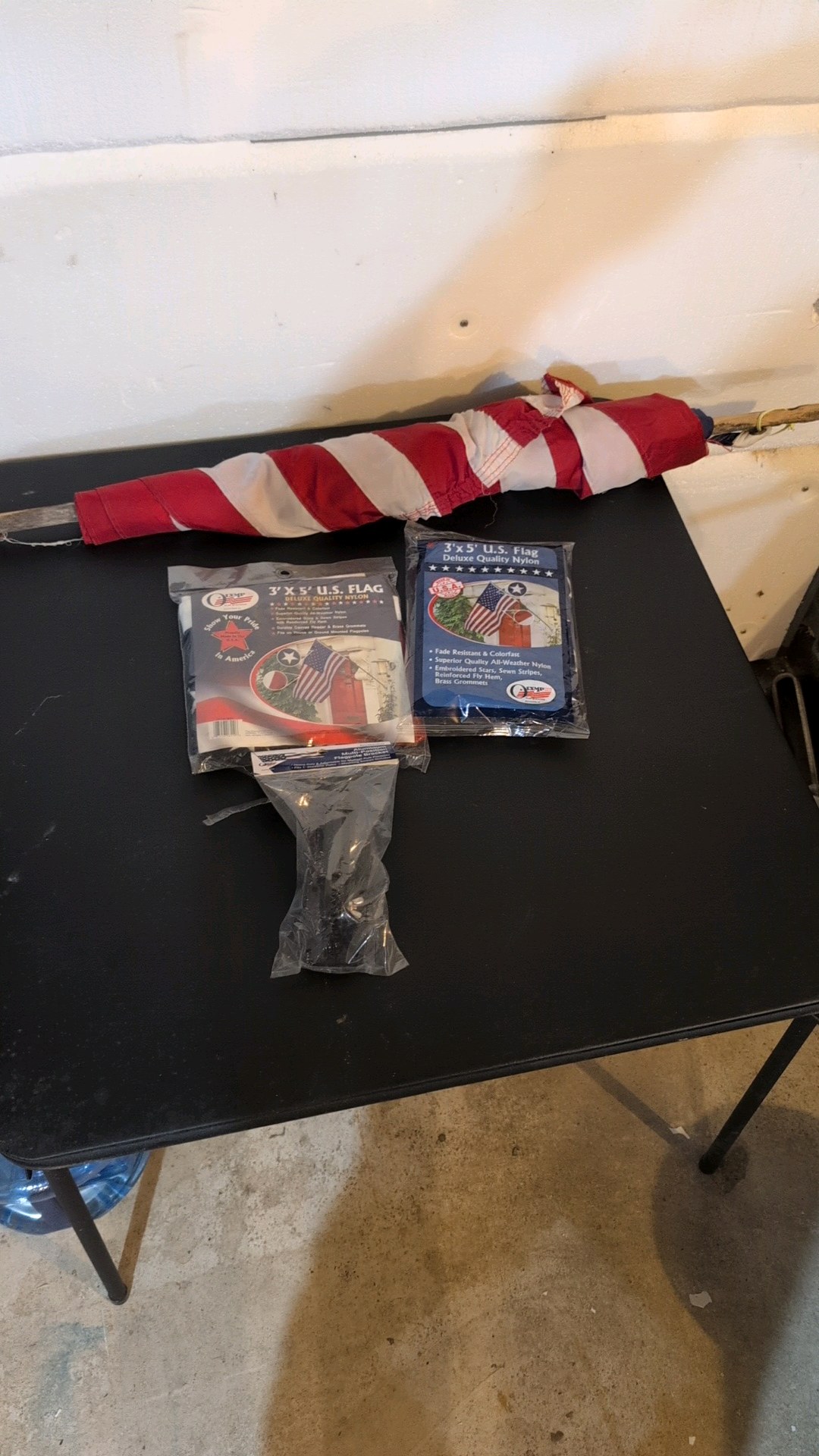 Three flags and flag holder. two flags are still in the bag