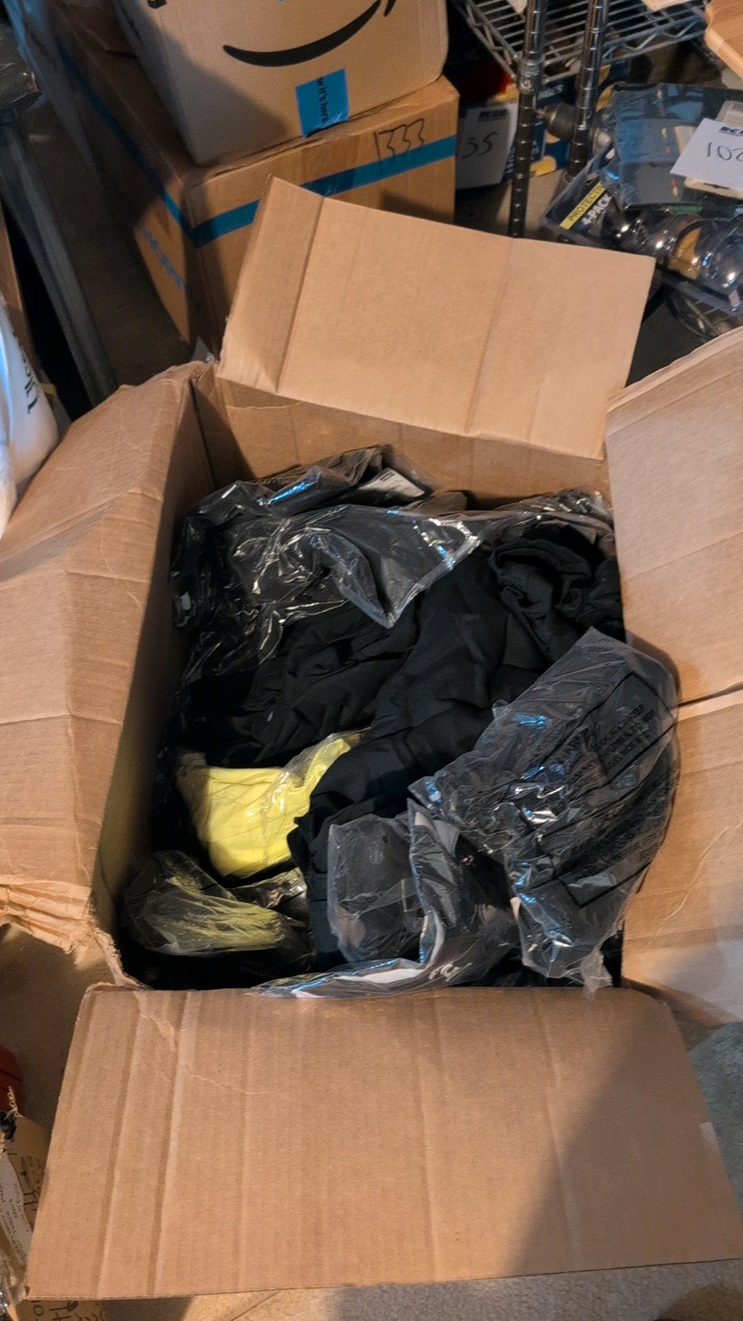 Large box of miscellaneous new shirts and clothing