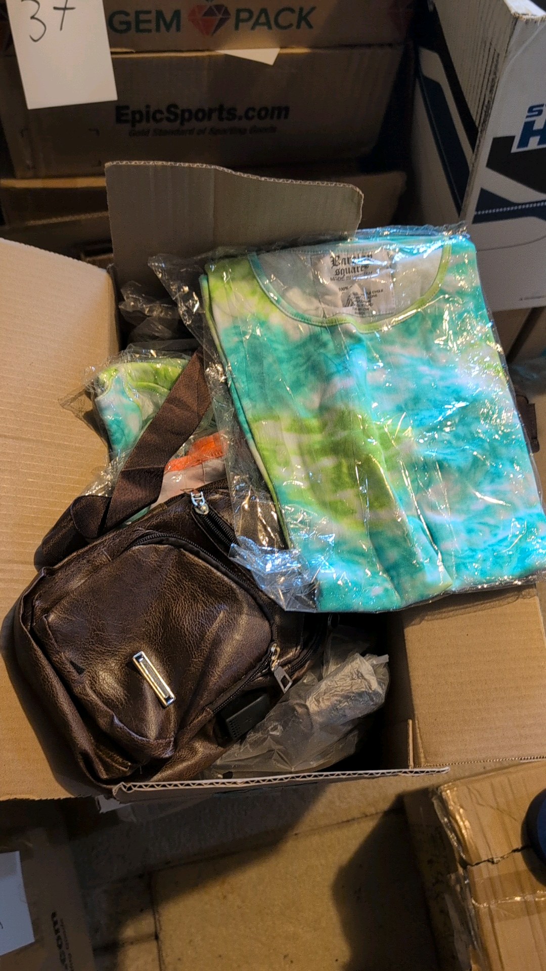 box of shoulder bags and tie-dye t-shirts