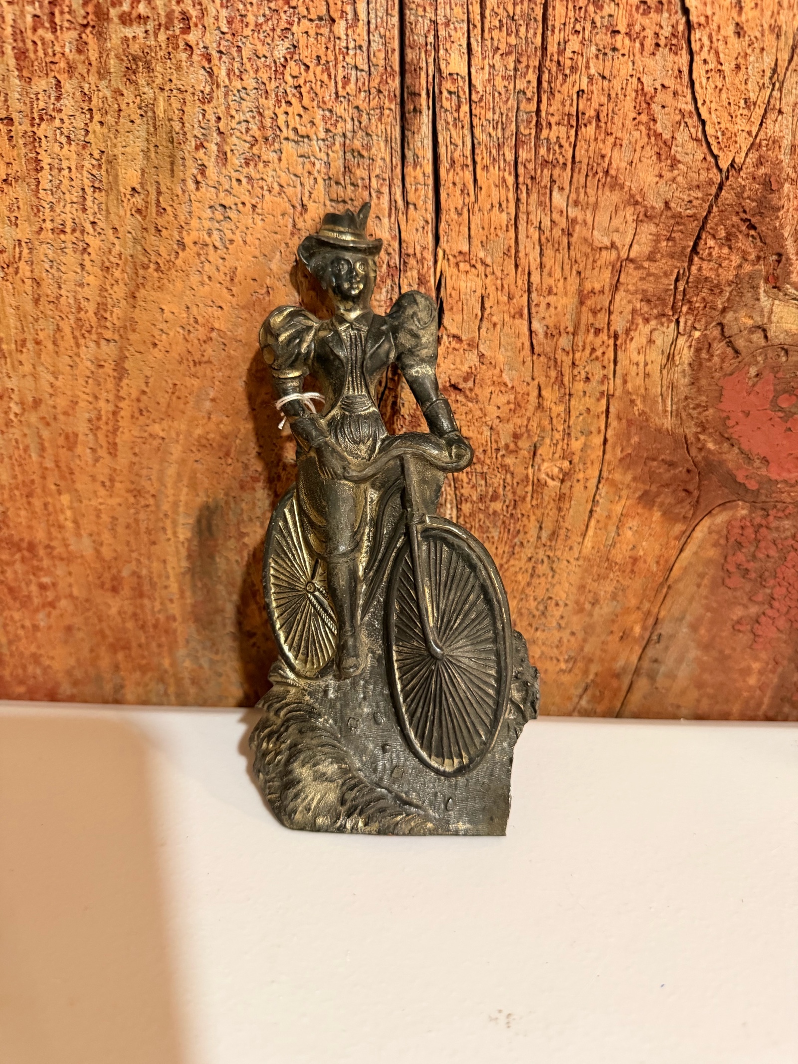 vintage pewter or bronze statue of a woman riding a bicycle