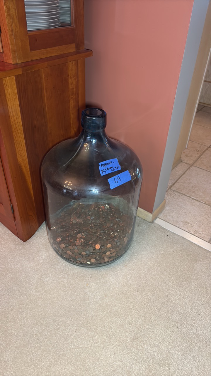 Glass gallon jug with pennies.