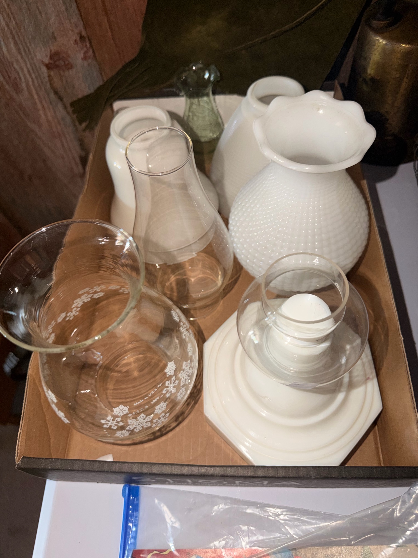 Various vintage lamp shades including white milk glass, a hobnail pattern shade, and a clear shade with etched snowflake designs.