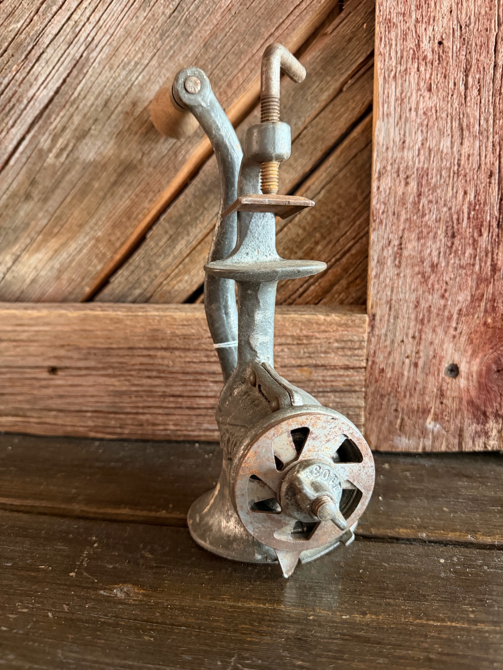 Cast iron hand-crank meat grinder.