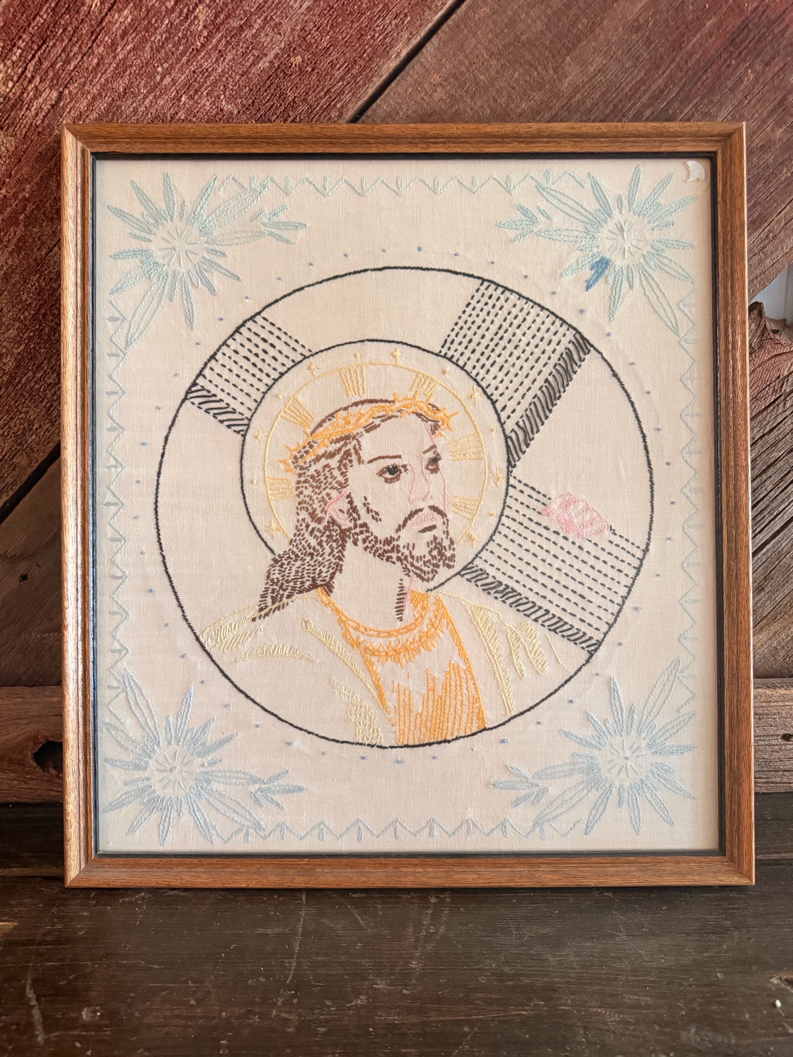 Vintage framed needlepoint embroidery depicting a portrait of Jesus Christ.