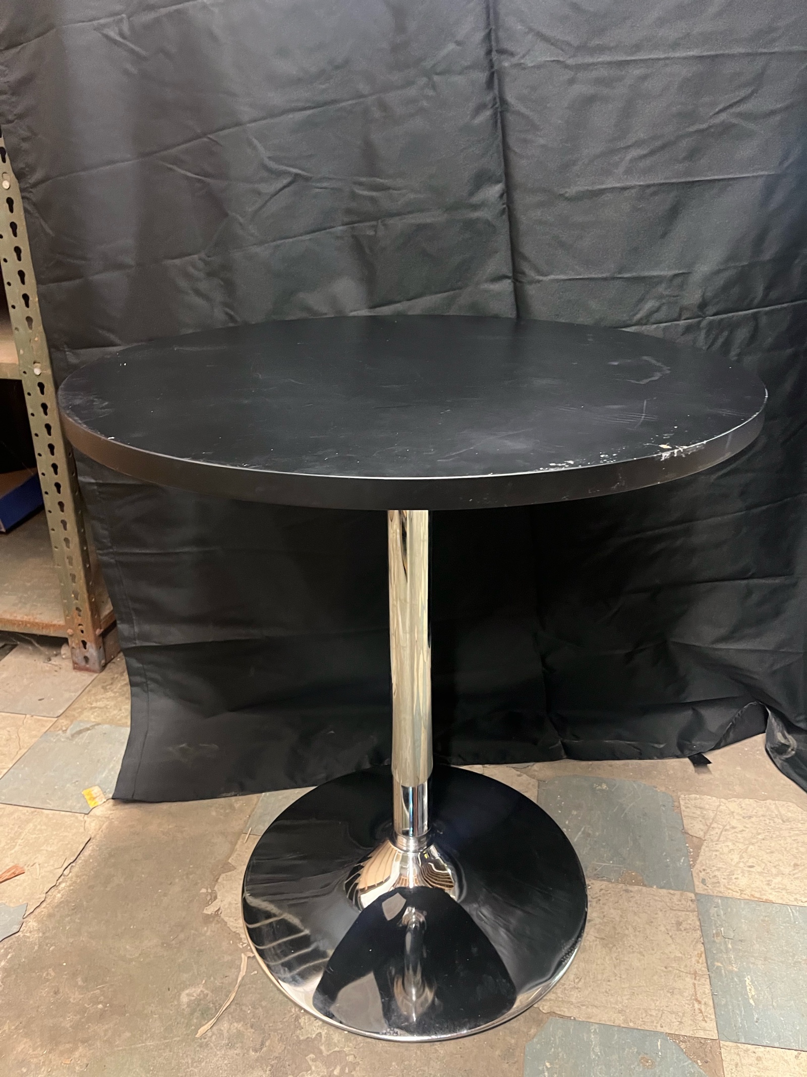 Two Piece Round 26 inch black table with chrome base  3 feet tall  minor scratches along edges