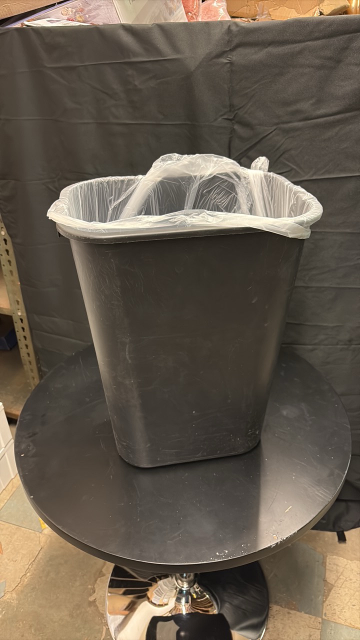 Black Plastic Trash Can About 2 Feet in Height, Comes With Roll of Garbage Bags in the Bottom